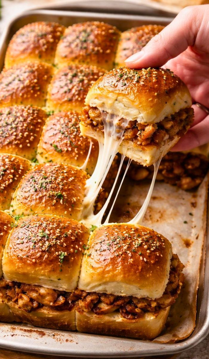 Use a rotisserie chicken from the store to make this a very fast 15-minute prep meal. Add cooked bacon bits inside the sliders for a smoky and salty flavor boost everyone loves. Swap the red onion for pickled jalapeƱos if you want a spicy kick in every bite. Use pepper jack cheese instead of mozzarella to add a little bit of heat to the sliders. Ensure the butter is slightly cooled before brushing so it does not soak into the bread too fast. Make these ahead of time and keep them in the fridge until you are ready to bake.